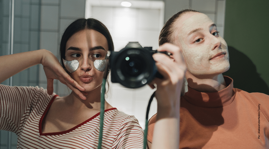 girls with face masks taking mirror selfies with camera